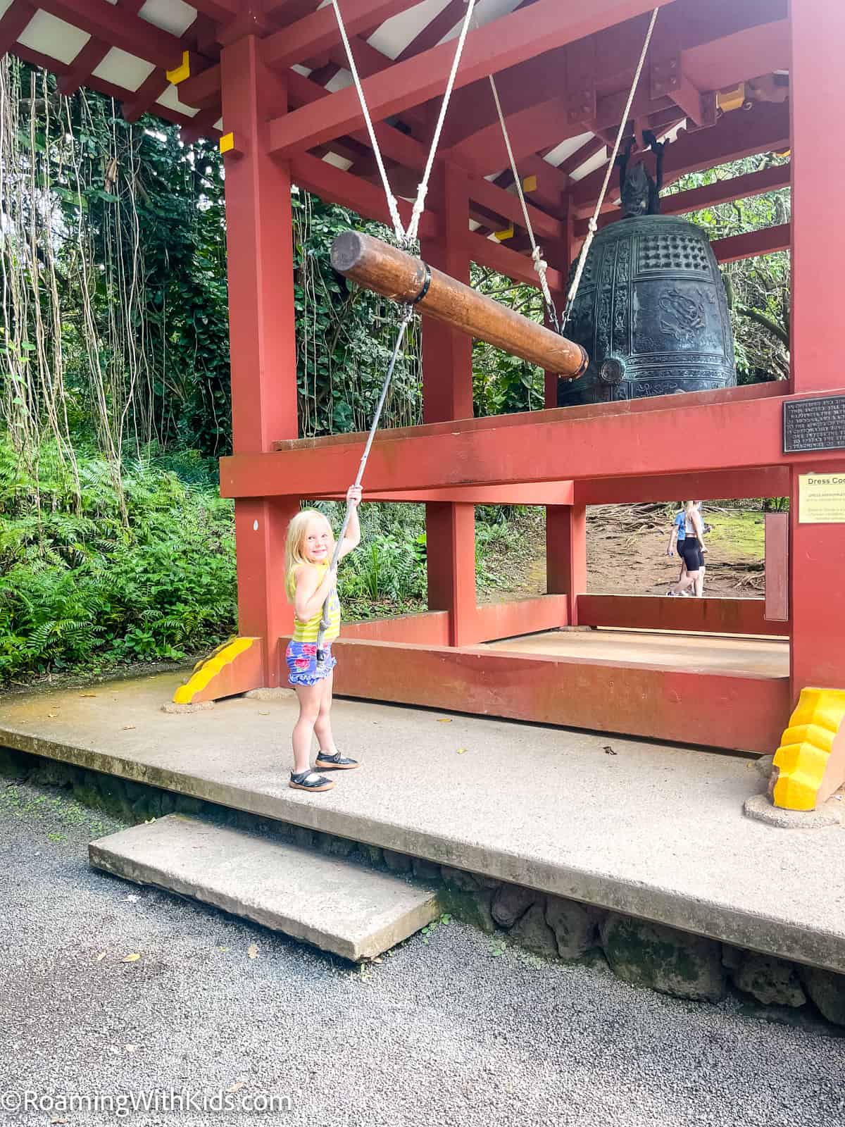 child ringing the bell at the Byodo-In Temple