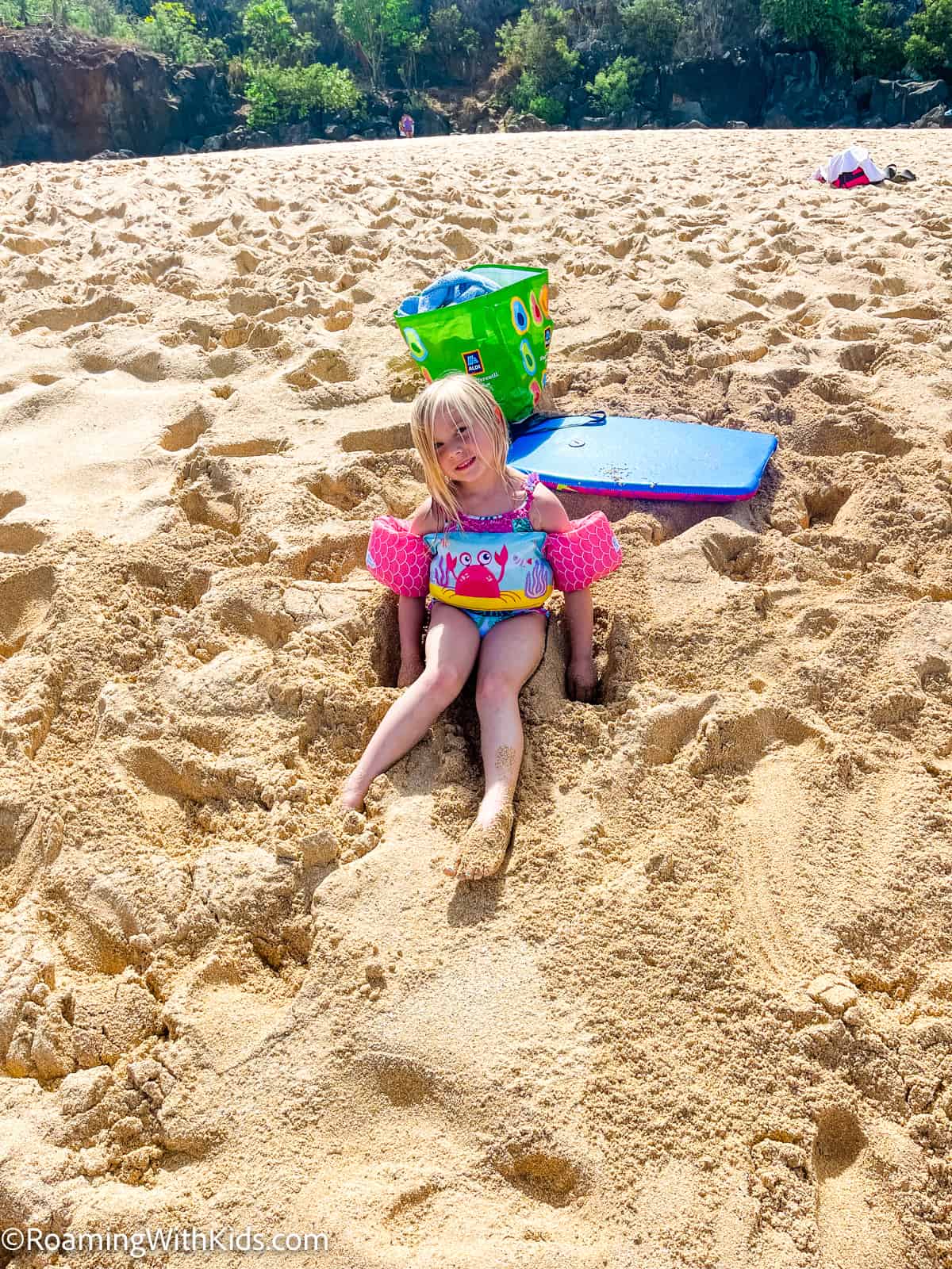 child playing in the sand at Waimea Bay beach park