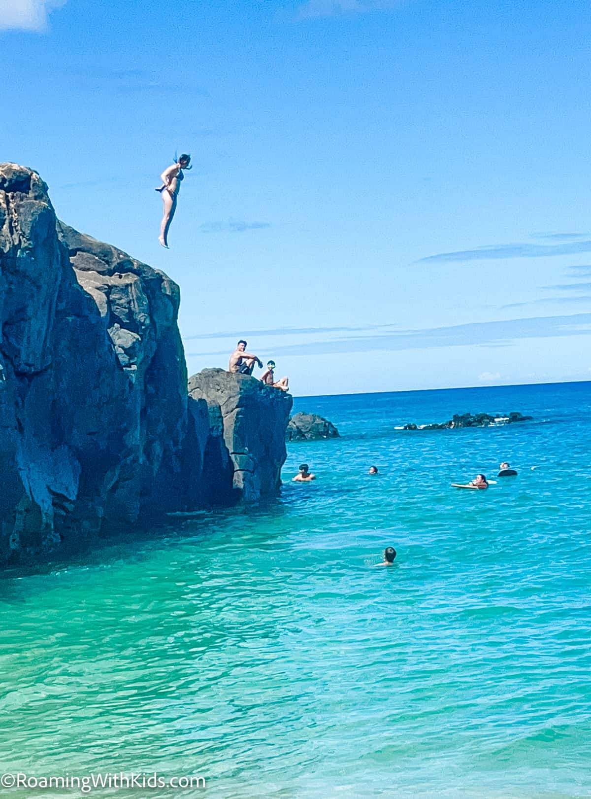kid Jumping off the big Rock at Waimea Bay Rock